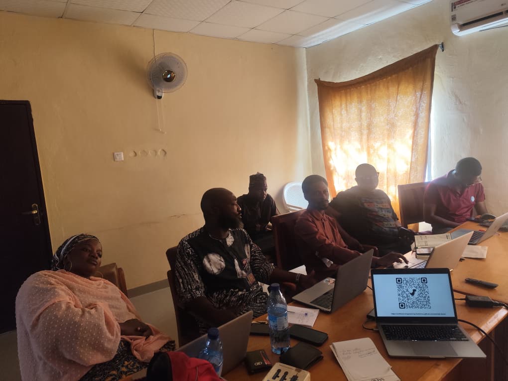 Staff seated around a table with laptops during the SWEMLab workshop