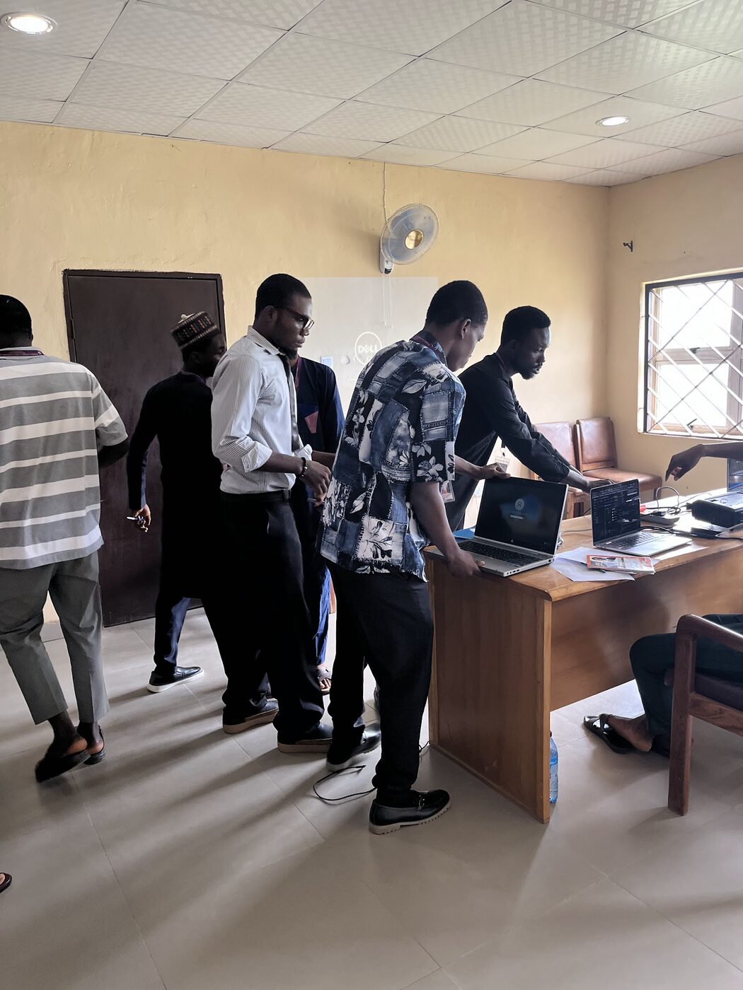 Lecturers and student team gathered around laptop